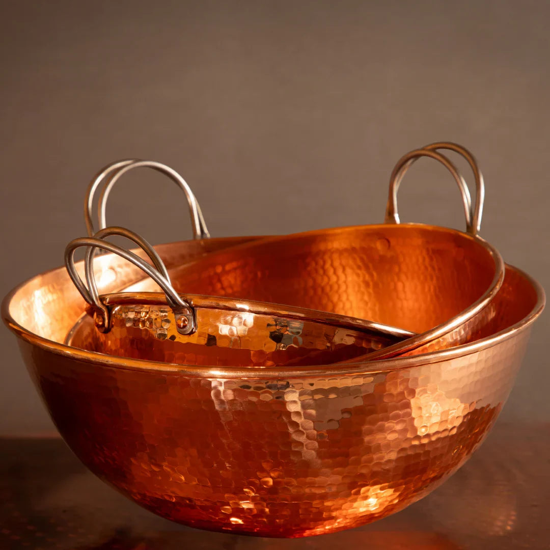 Copper pot with handles on a dark background